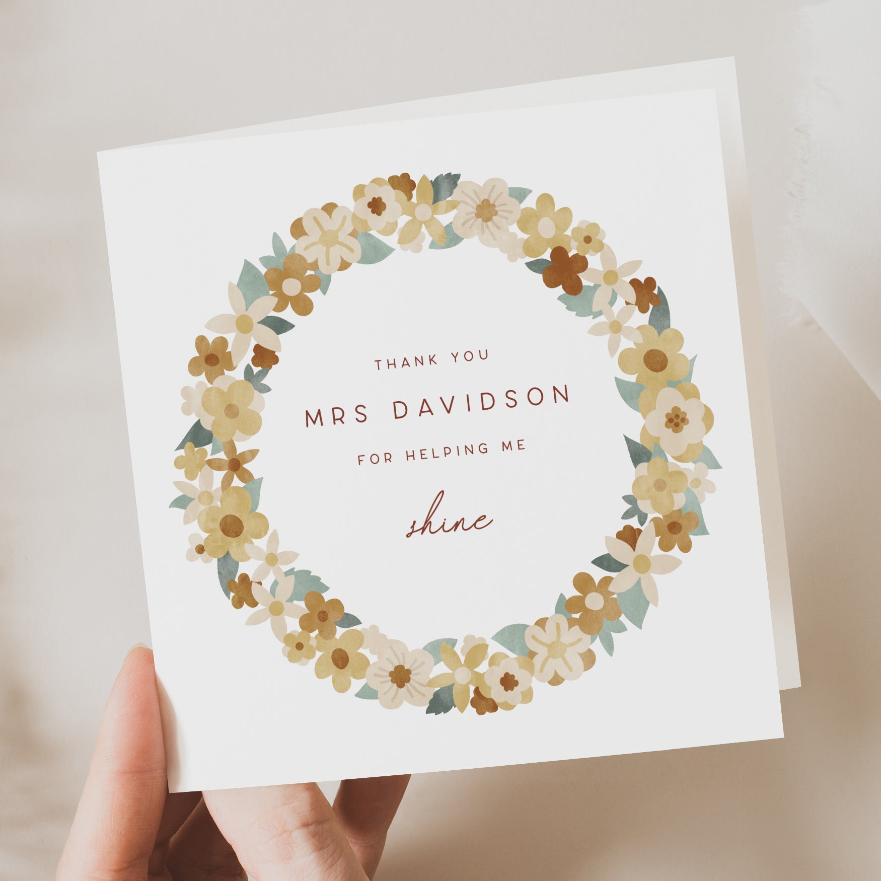 Personalised thank you card for teacher with a circular floral wreath design. Features the name “Mrs Davidson” and message “Thank you for helping me shine.”