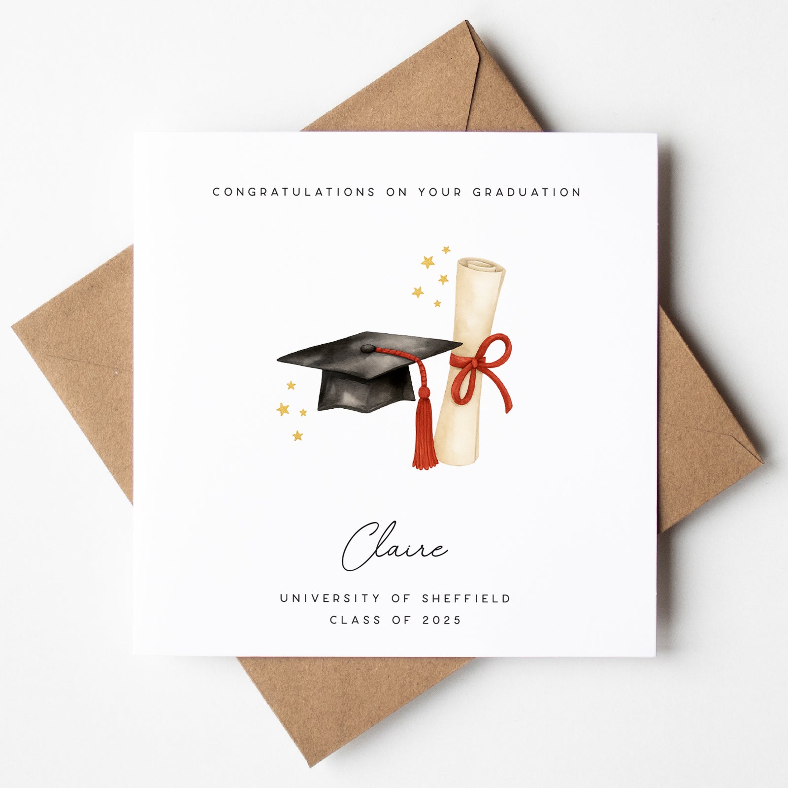 Personalised graduation card featuring a black mortarboard with red tassel, a diploma scroll tied with a red ribbon, and gold stars. Includes the message “Congratulations on your graduation,” the name “Claire,” and “University of Sheffield – Class of 2025.” Displayed with a kraft brown envelope.