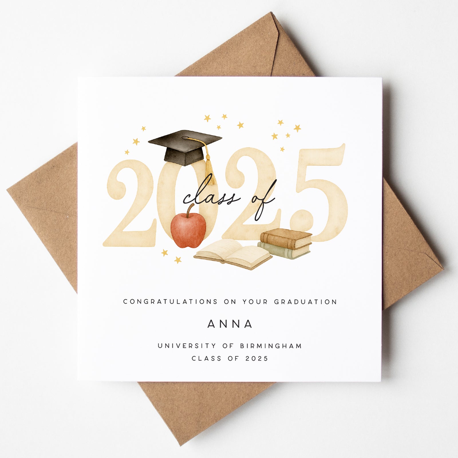 Personalised graduation card for the Class of 2025 featuring a mortarboard, books, open notebook, red apple, and gold stars. Customised with graduate's name, university, and graduation year. Card shown with kraft envelope.